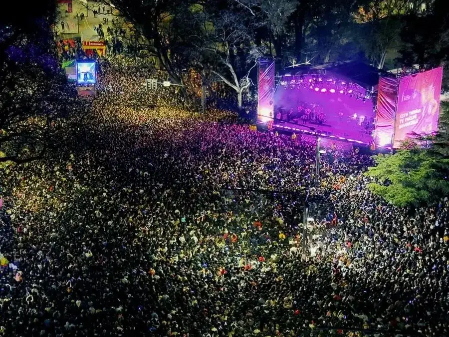 Una multitud colma los Fan Fest durante la noche, disfrutando de un show en vivo sobre el escenario principal.