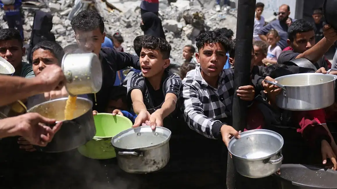 Palestinos desplazados se reúnen para recolectar porciones de comida en una distribución benéfica en Jabalia, al norte de Gaza. (Foto: BASHAR TALEB/AFP/AFP via Getty Images)