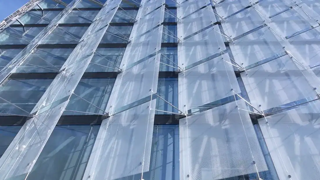 Las “velas” de vidrio toman el ángulo de la ochava y protegen la fachada oeste de un edificio en España, un ejemplo de las posibilidades de las dobles pieles.