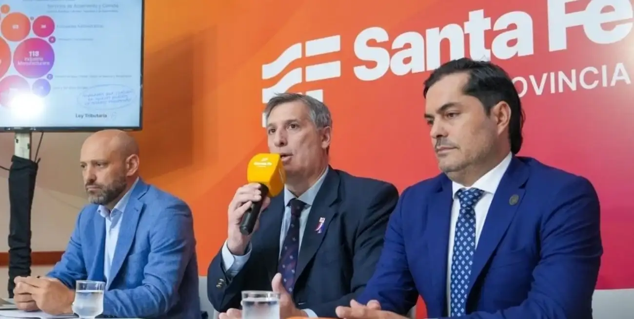 De izquierda a derecha, los ministros Gustavo Puccini (Desarrollo Productivo), Pablo Olivares (micrófono en mano, Economía) y Roald Báscolo (Trabajo, Empleo y Seguridad Social), en oportunidad de brindar detalles de la política impositiva del gobierno de la provincia de Santa Fe.