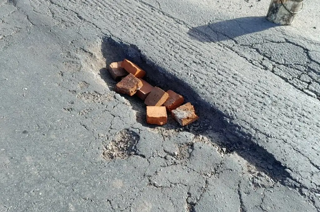 Vecinos colocaron ladrillos para “protegerse” del pozo en ruta 11, km 618, entrada sur de Gobernador Crespo. Foto: Ruta 11 En Emergencia