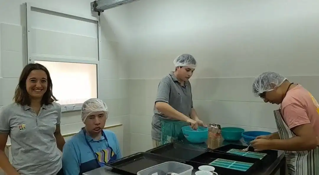 Magdalena -coordinadora del taller- con los jóvenes en la elaboración de alimentos saludables, otro de los emprendimientos del centro. Foto: Gentileza.