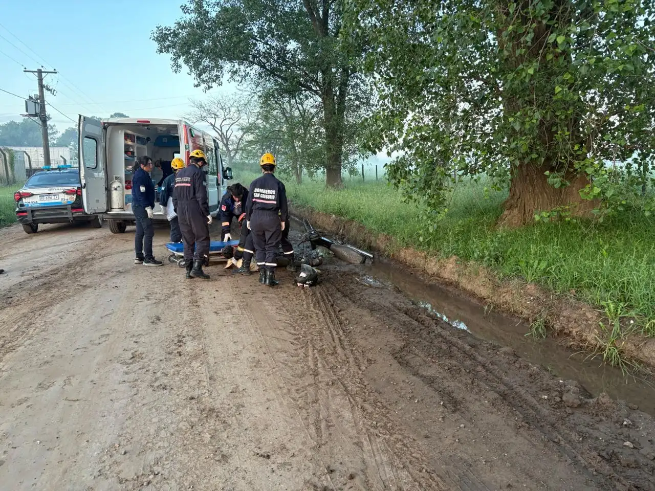 Personal de bomberos atendiendo al motociclista accidentado.