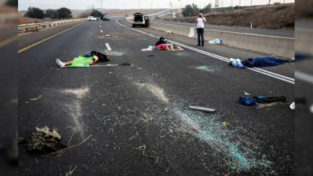 Una persona toma fotos de cadáveres desperdigados en una autopista