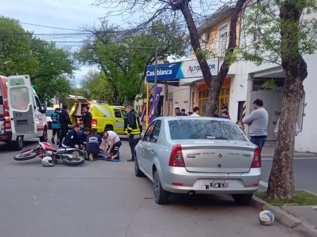 Personal de Bomberos y servicios de emergencia asisten a una persona tras un accidente vial de una motociclista que cayó a la calle tras pisar una pelota.