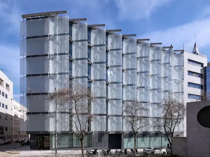 Las “velas” de vidrio toman el ángulo de la ochava y protegen la fachada oeste de un edificio en España, un ejemplo de las posibilidades de las dobles pieles.