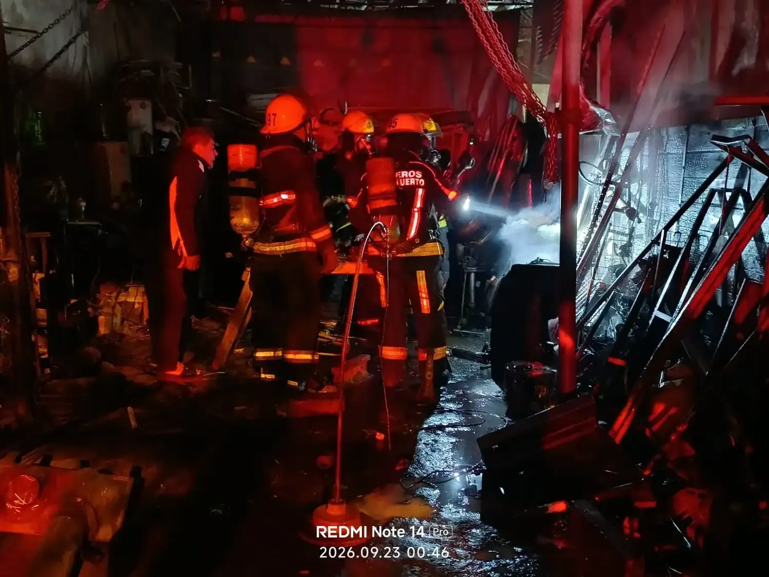 Dotación de Bomberos Voluntarios de Venado Tuerto trabaja en la extinción de un incendio dentro de un taller mecánico local.