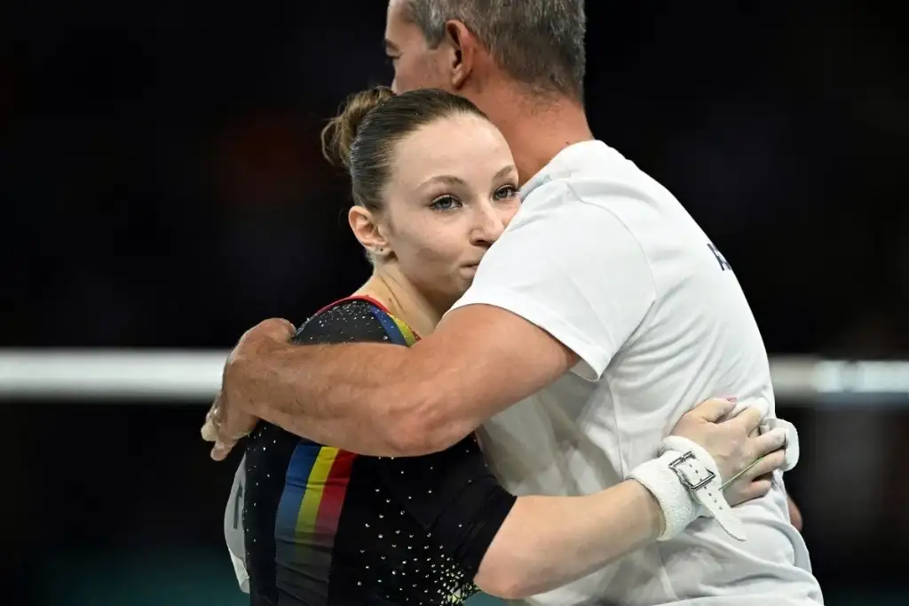Ana Barbosu fue consolada por su entrenador tras perder la medalla de bronce.
