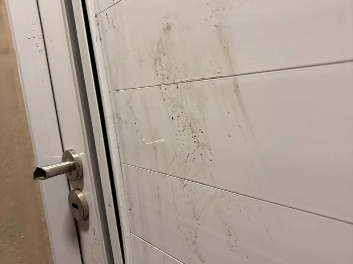 La puerta dañada por el hombre detenido.