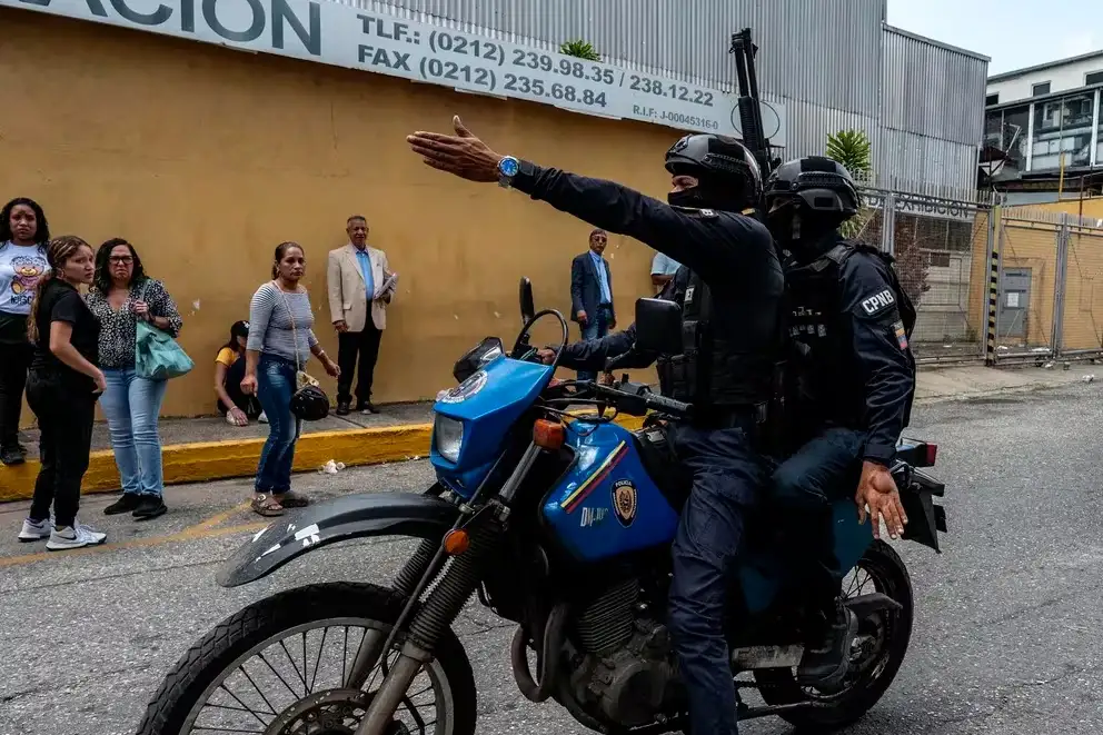 Agentes de policía gritando instrucciones a familiares de manifestantes detenidos en Caracas (Crédito: Alejandro Cegarra para The New York Times)