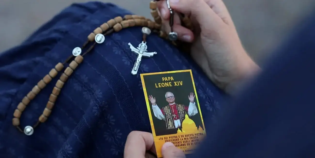 Una mujer sostiene un rosario y una estampa con la imagen del Papa León XIV a las afueras del Hospital Gemelli, donde el Pontífice recibe tratamiento para el cáncer de pulmón tras una cirugía para extirparle parte del pulmón derecho. Crédito: REUTERS/Yara Nardi
