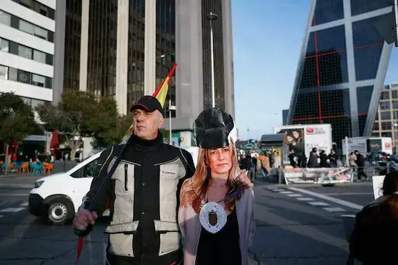 Una persona con una máscara de Begoña Gómez ante los Juzgados de Plaza de Castilla.