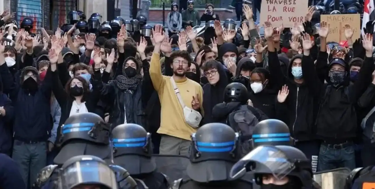Francia dividida y enfrentada. De un lado los manifestantes, frente a ellos las fuerzas de seguridad. El cartel del fondo es un pedido al presidente francés que expresa realmente mucho más de lo que dice: "Macron, cruza la calle para ver". Gentileza
