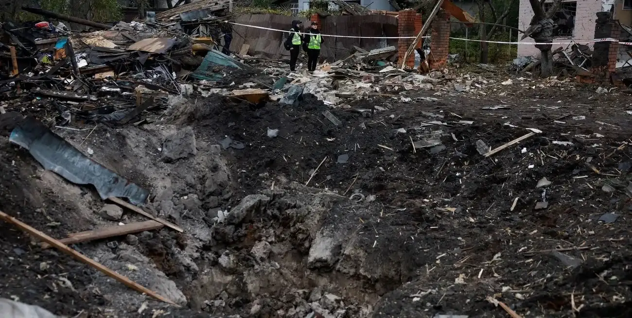 Agentes de policía observan un cráter que apareció en una zona residencial tras ataques con misiles rusos durante la noche, en el marco de la ofensiva de Rusia contra Ucrania, en Kiev, Ucrania. REUTERS/Valentyn Ogirenko.