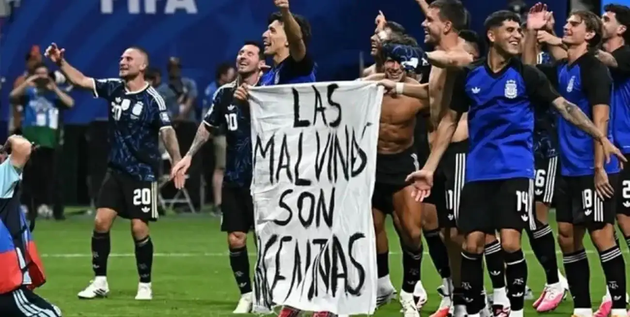Parte del plantel argentino muestra orgulloso la bandera con la leyenda sobre las Islas Malvinas tras el triunfo ante Inglaterra.