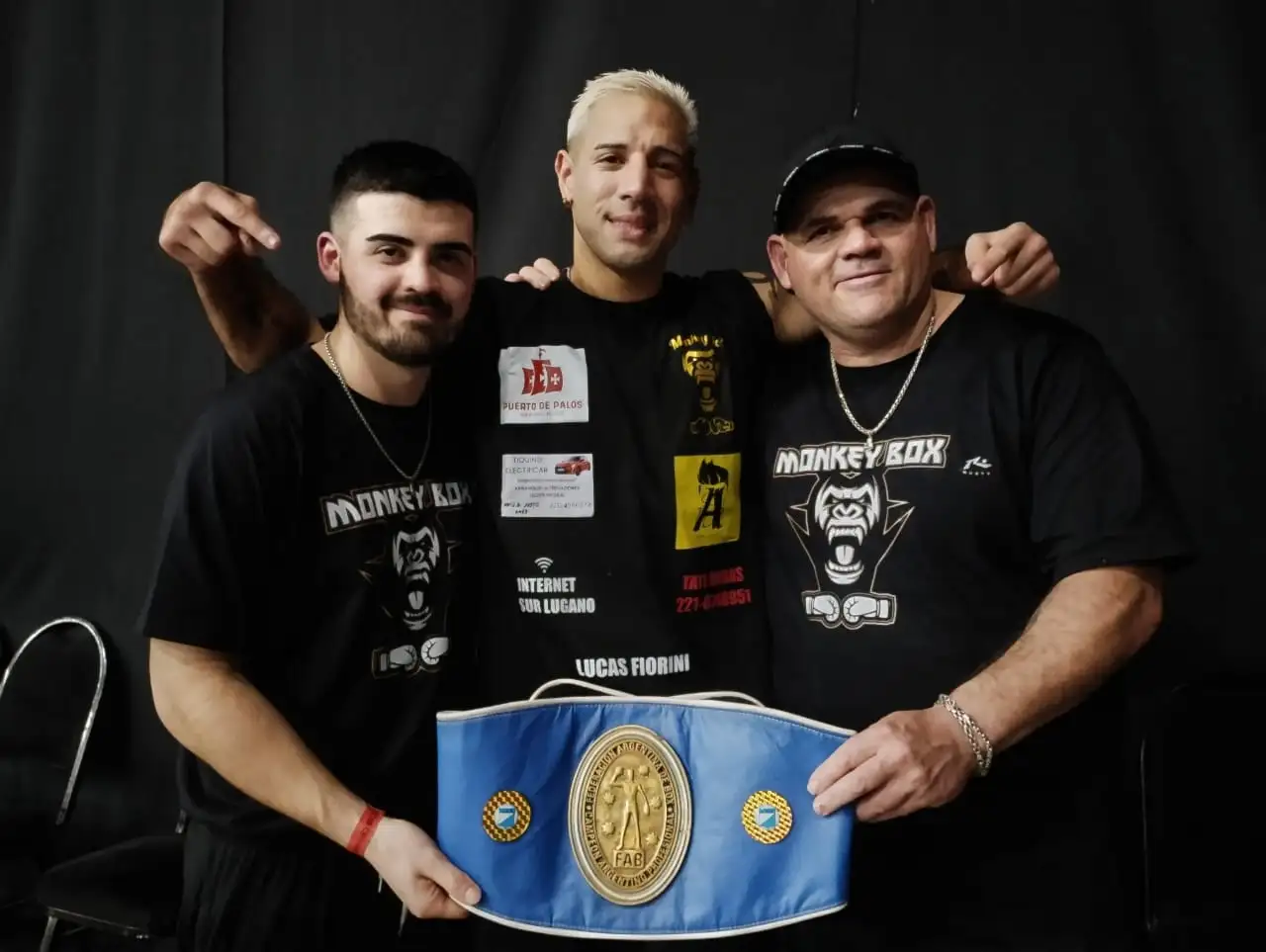 Lucas Bastida con el título argentino junto a su rincón.