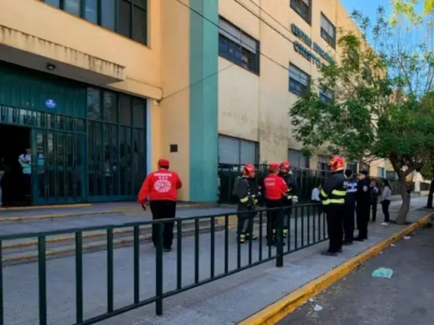Personal de bomberos y fuerzas de seguridad trabajan en el frente del colegio de Córdoba donde ocurrió el grave accidente durante una clase de química.
