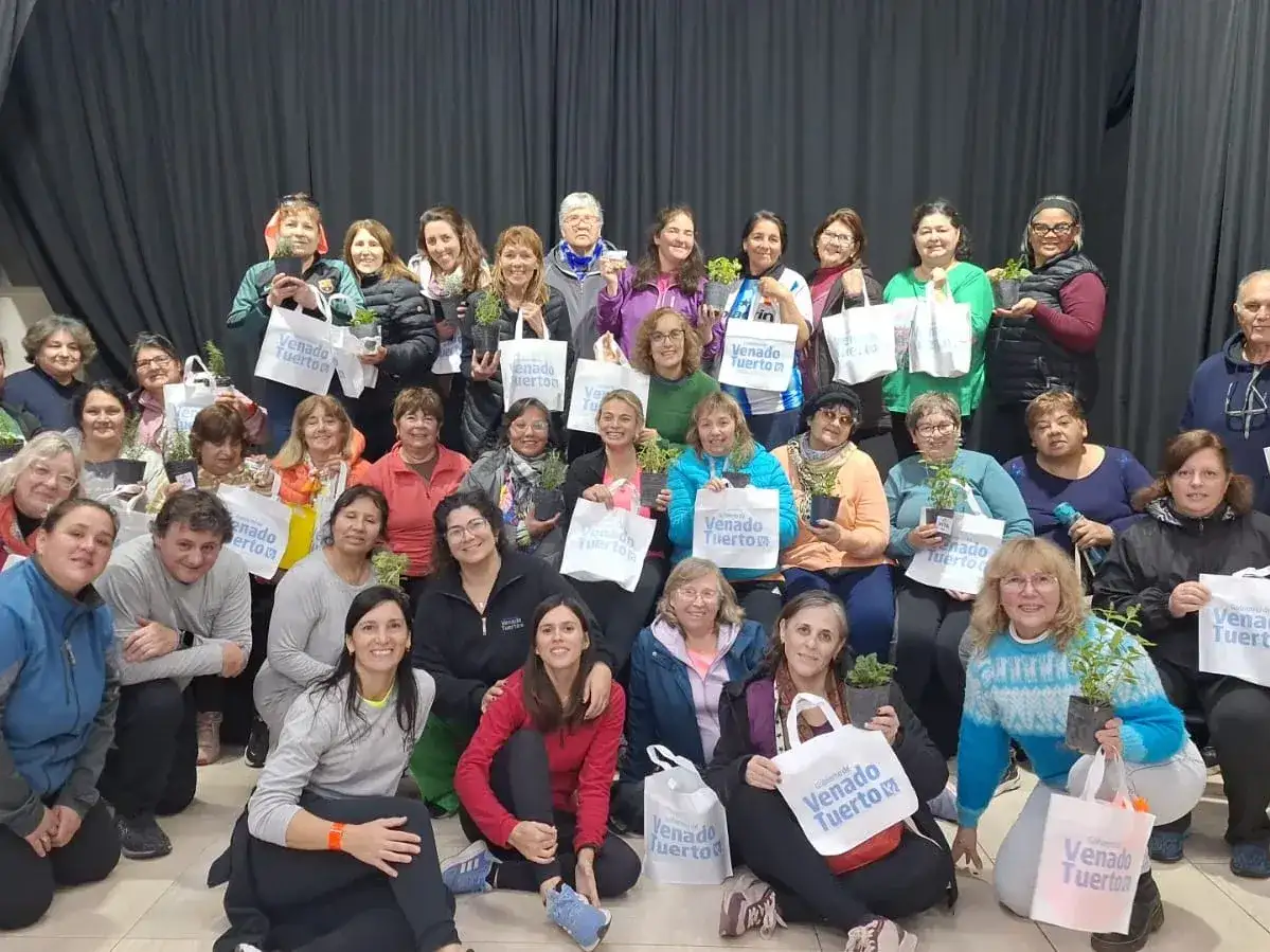 Participantes del Programa Vita junto a autoridades locales en Venado Tuerto, donde recibieron plantines y bolsas institucionales como parte de las acciones de acompañamiento integral impulsadas por el municipio para fortalecer la huerta familiar.