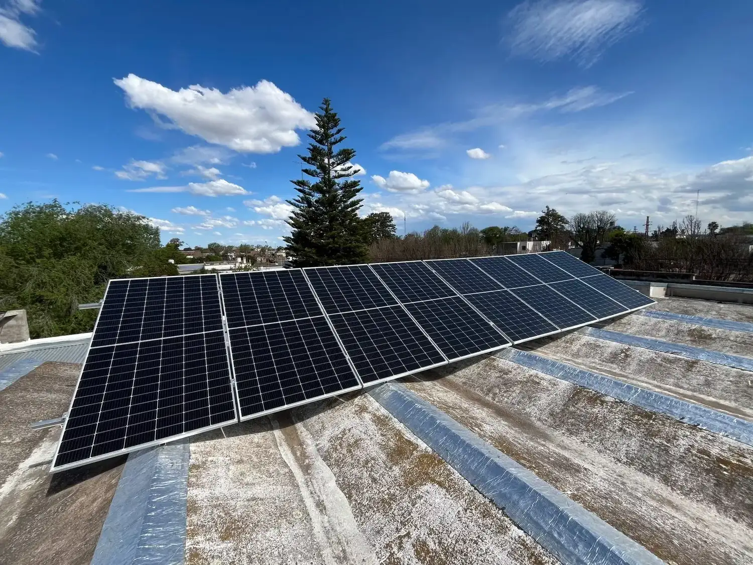 Paneles solares instalados sobre el techo de una institución educativa, promoviendo la generación de energía renovable y el ahorro energético en las escuelas de la provincia bajo el plan de inversión en infraestructura sustentable.